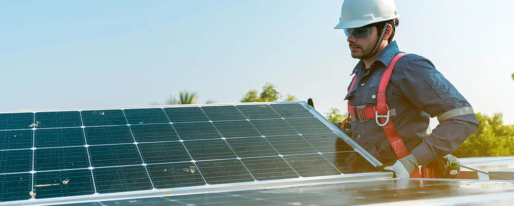 Ein Techniker installiert die Sonnenkollektoren auf dem Dach eines Hauses und Heimbüros